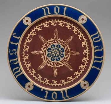 A bread plate with a symmetrical design and details of wheat plants and the inscription "Waste not, want not"