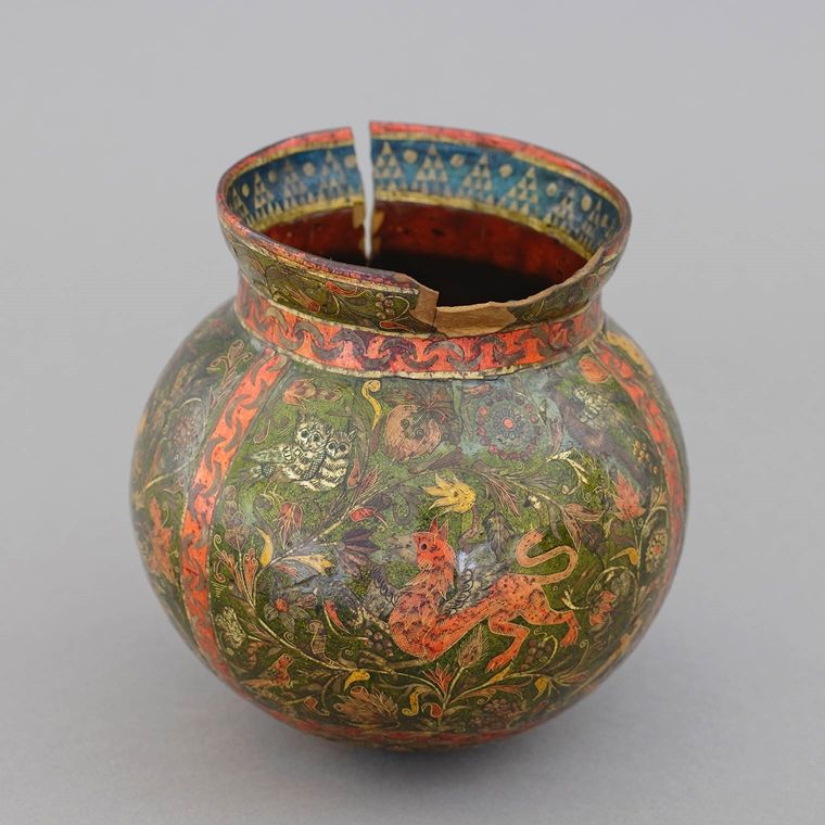 Primarily green and orange multicolored vessel with scenes of animals and nature.