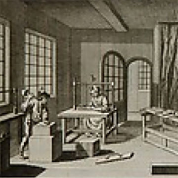 A black and white print featuring two individuals in a workshop.