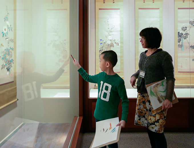 A child and mother view a display in the Asian art galleries