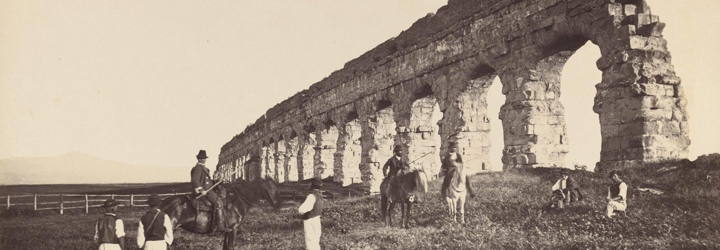 Mid-19th-century photograph of men on horseback near a Roman aqueduct