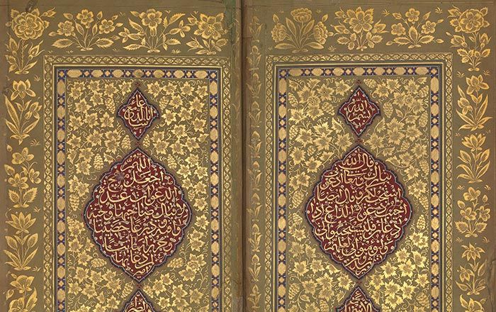 Detail of an Islamic Book of Brayers with gold illustrations of flowers surrounding a crimson design containing Arabic text 