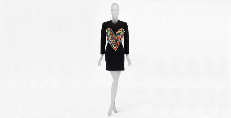 Black dress by Patrick Kelly with a large collection of colorful buttons in the shape of a heart on the bodice