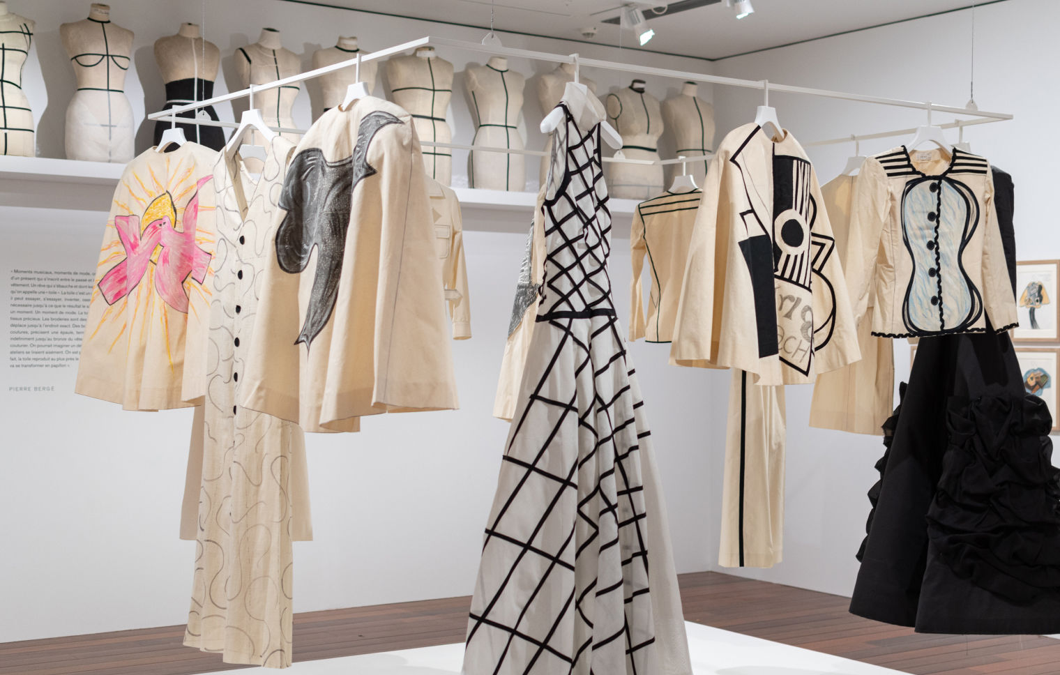 Muslin designs hang from the ceiling showcasing in-progress designs by Yves Saint Laurent