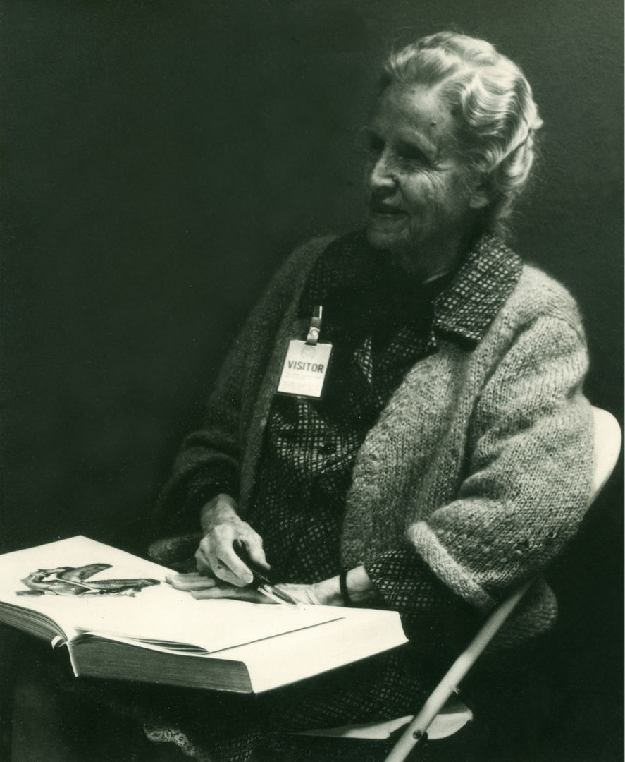 Black and white portrait of Anita Reinhard sitting down with an open book
