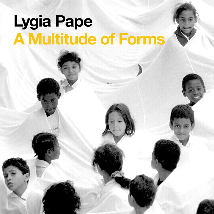 Black-and-white photograph of a group of boys and girls emerging from one white, continuous cloth; the children face off in multiple directions; the following overlay text appears in the upper left corner: "Lydia Page A Multitude of Forms"
