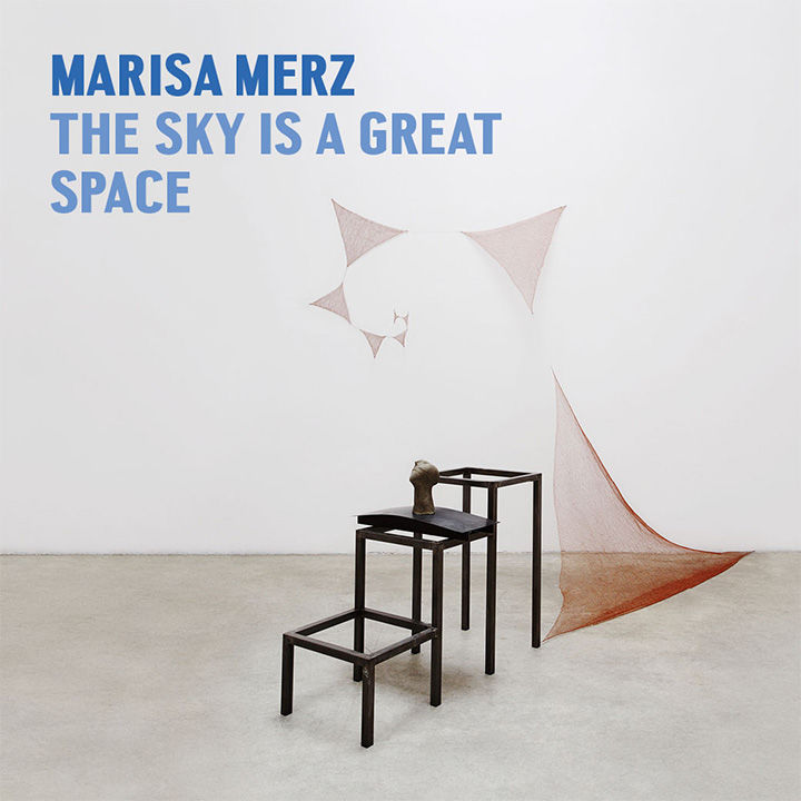 Photograph of an abstract sculpture within a gallery room comprised of three stick-frame square tables of gradual heights with a portrait bust sculpture on the middle table followed by a suspended spiral textile sculpture; the following overlay text appears in the upper lefthand corner: "Marisa Merz The Sky Is A Great Place"