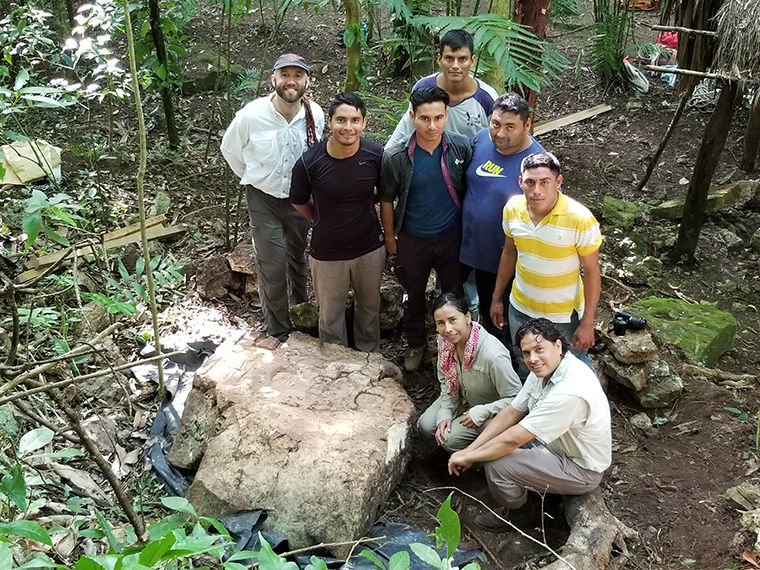 The archaeological team gathered around an excavated stele