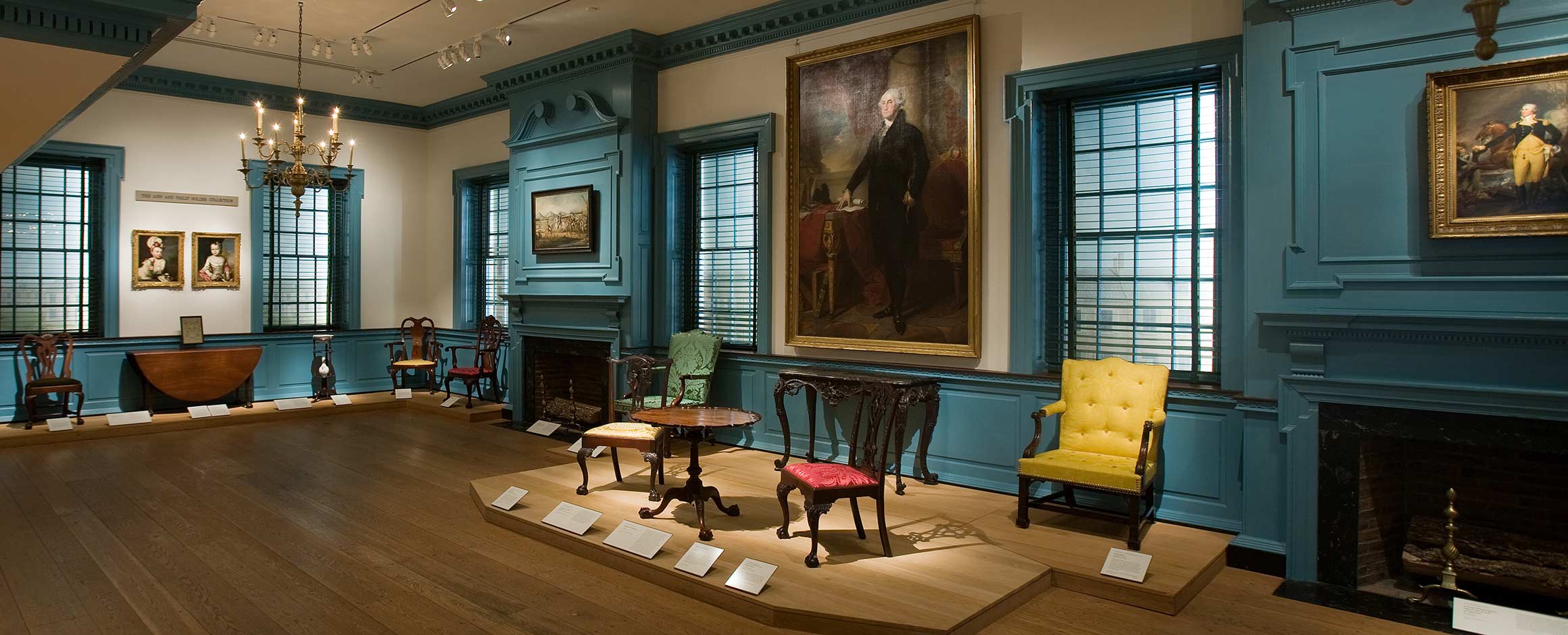View of the Alexandria Ballroom with furniture on display and two paintings of George Washington