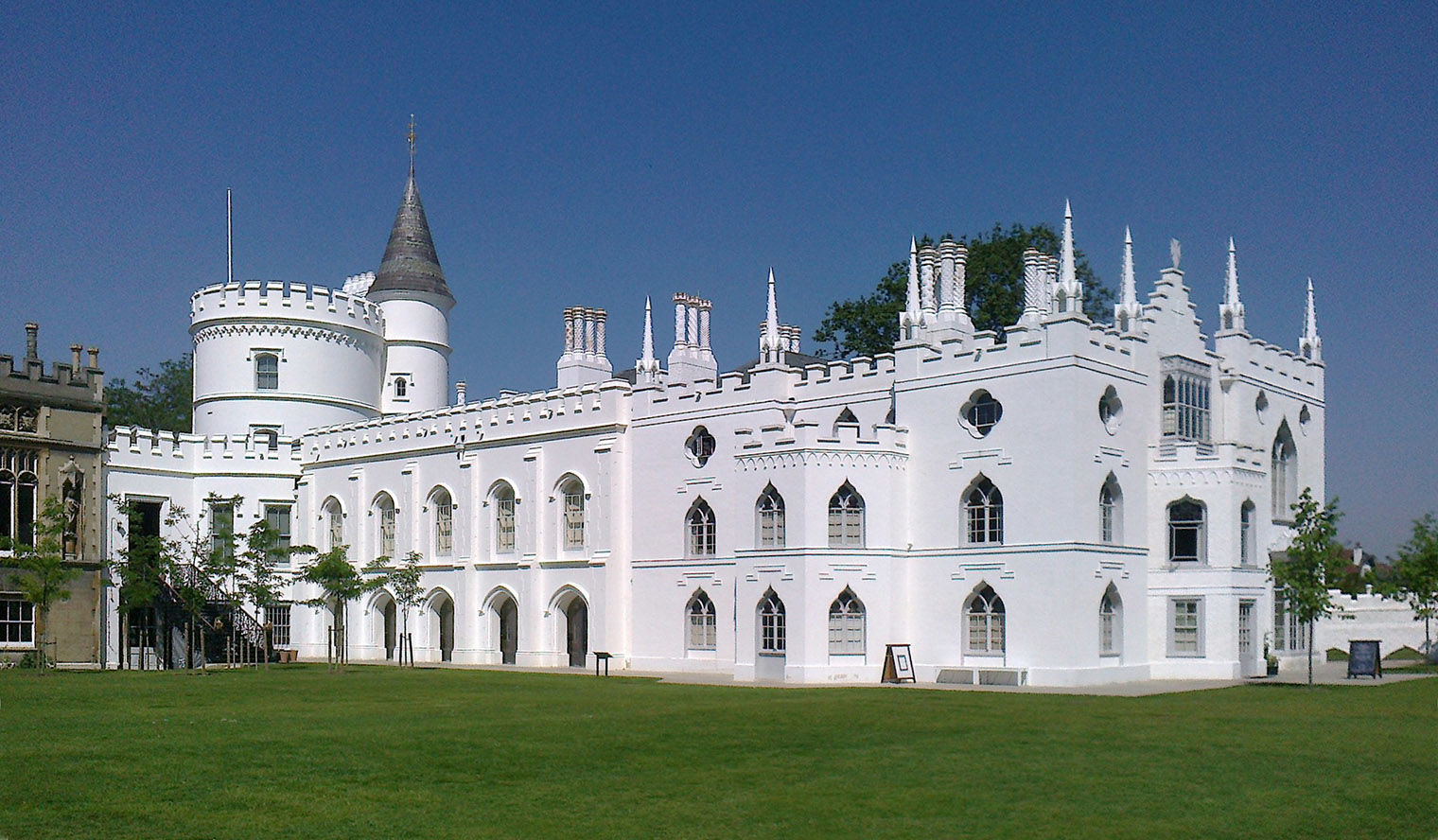 A large white castle with a large lush lawn