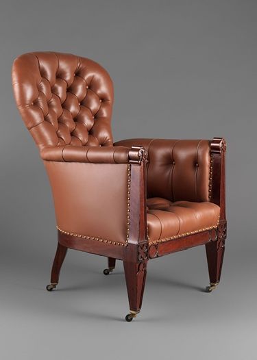 A large apholstered easy chair with a wheel on each leg