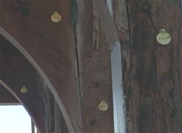 Metal identification tags hanging on wooden beams