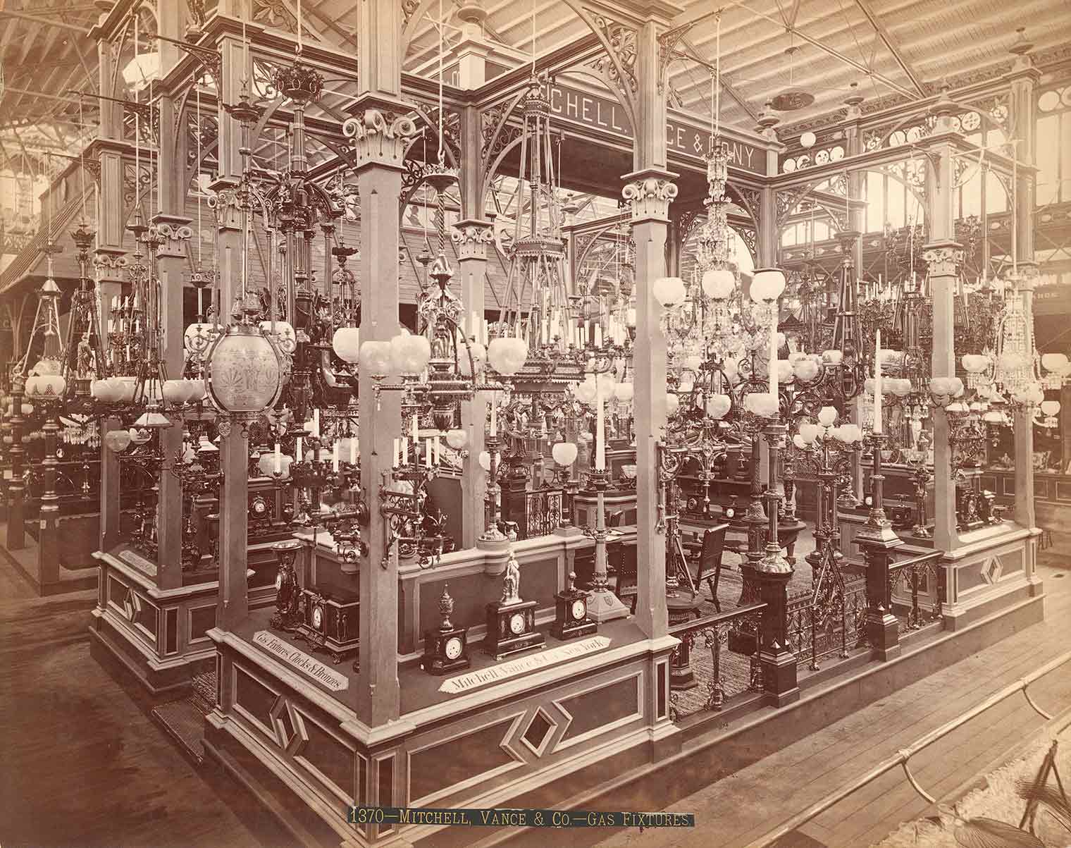 Sepia-toned photograph of a large group of similar light fixtures on display in a warehouse 