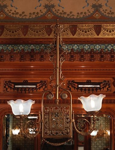 A late-19th-century brass lighting fixture with mother-of-pearl inlay and organic forms.