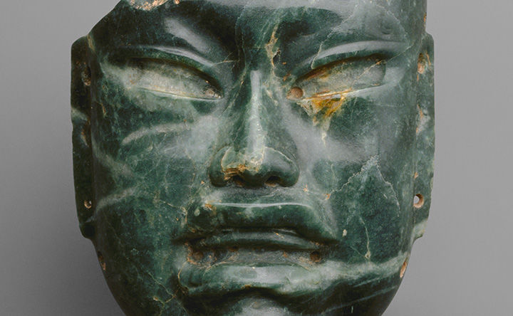 Carving of a face in green stone.