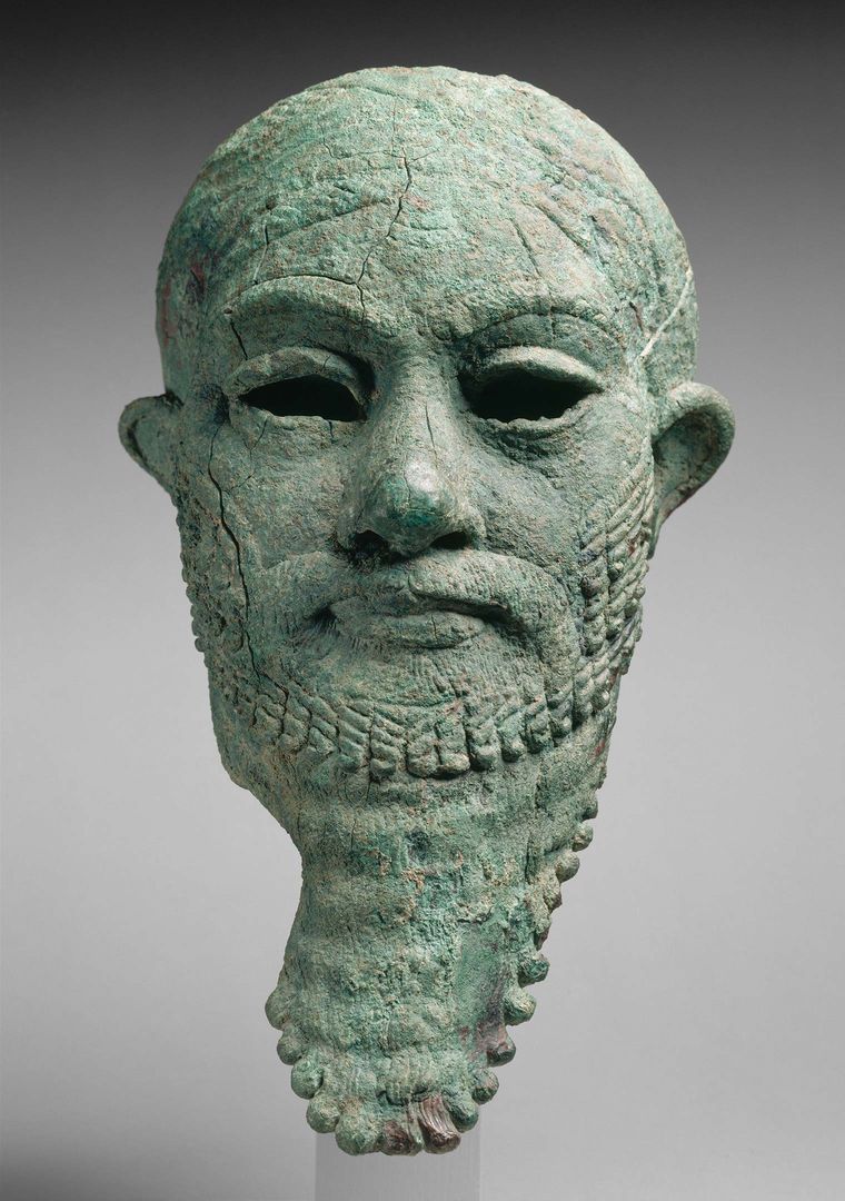 Limestone statue of a head with a slach across the forehead to the chin