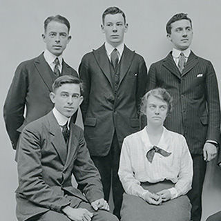 A black-and-white photo of four men and a woman—the original staff of the Arms and Armor department