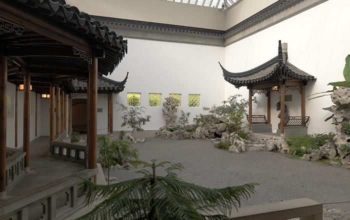 An interior courtyard with pagodas, plantings, ornamental rocks, and a fish pond