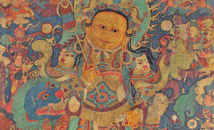 A round faced figure with multiple shields and body ornaments amid a colorful background