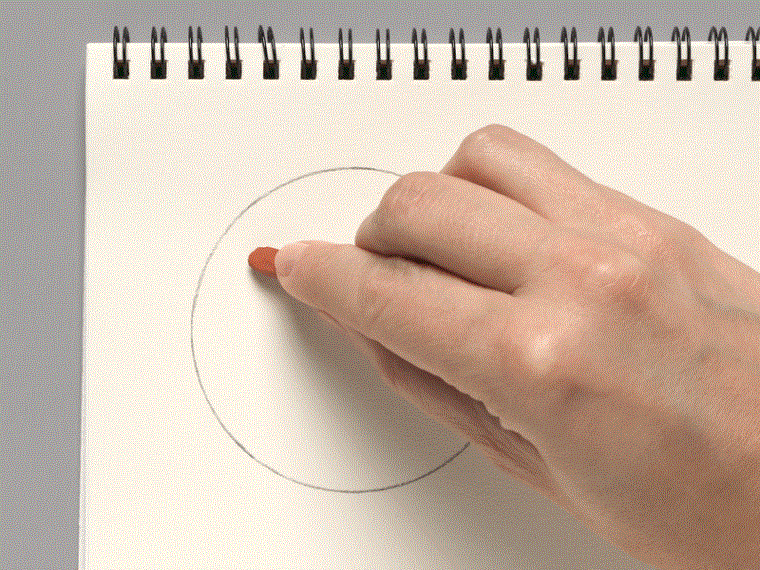 A moving image of a hand making small swooping marks on paper with a piece of red chalk.