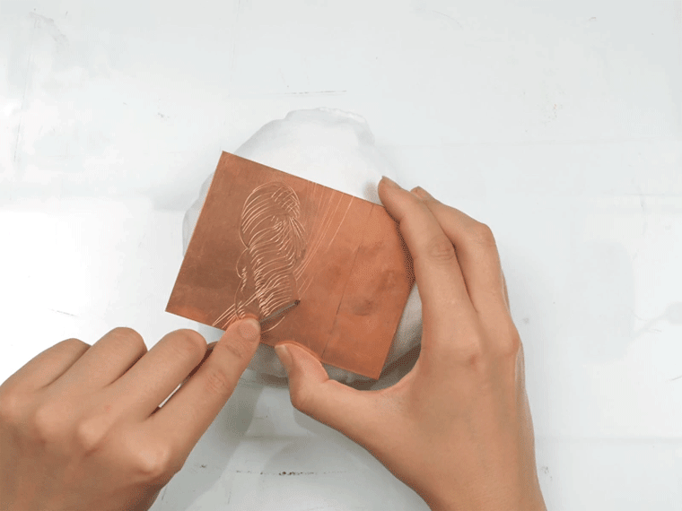 Animated image of an artist engraving on a plate atop a pillow