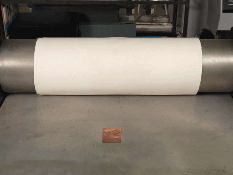 Animated image of an engraving plate being run through a printing press