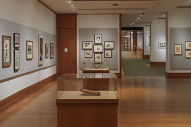 Room with wooden floors and prints on a gray wall