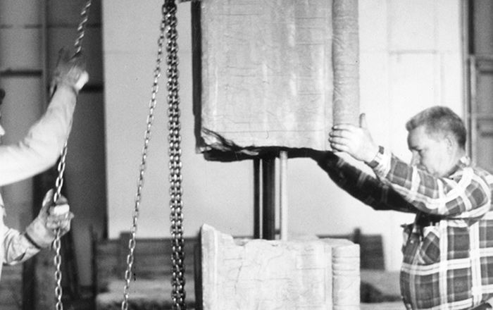 A black and white image depicting two men joining fragments of a block from the temple prior to its reassembly in the 1970s