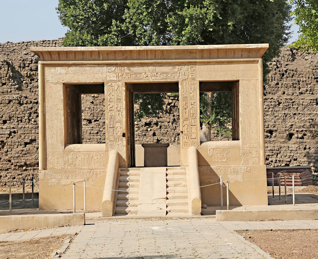 Square building with a ramp leading to the interior and large openings on all sides. The walls are covered with hieroglyphs.