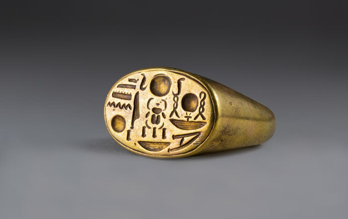 A gold ring engraved with hieroglyphs.
