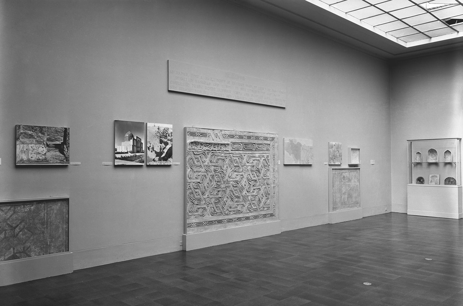 Black and white photo of gallery from 1949 with Nishapur stucco panels on the wall