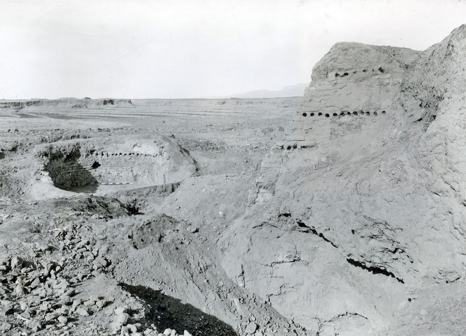 Black and white photograph of an excavated kiln with holes that held the ceramics