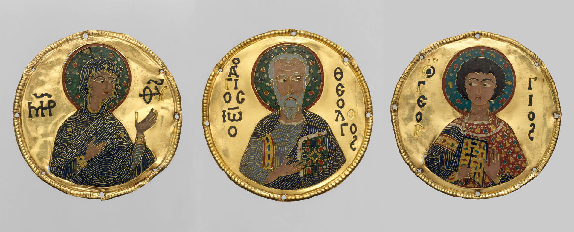 Three Byzantine-era medallions against a gray background. From left to right, the medallions depict the Virgin Mary, Saint John the Evangelist, and Saint George in colorful, gold-accented detail.