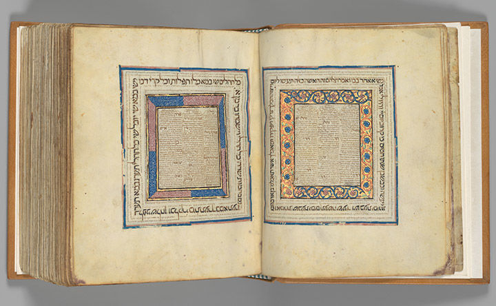 Two-page spread from a Hebrew Bible with organic ornamentation in blue, pink, and gold.