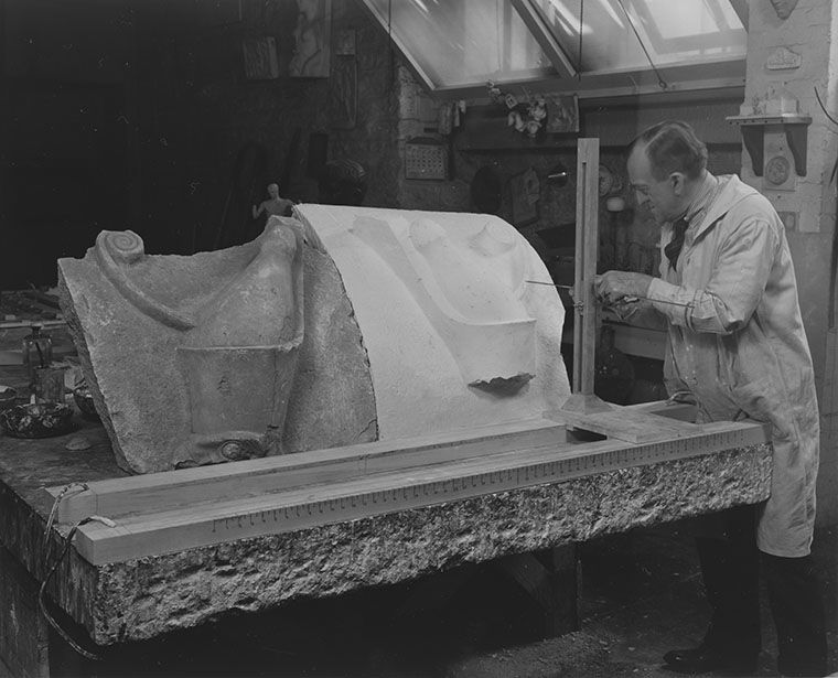 A conservator using a large machine to create a plaster mold of an object
