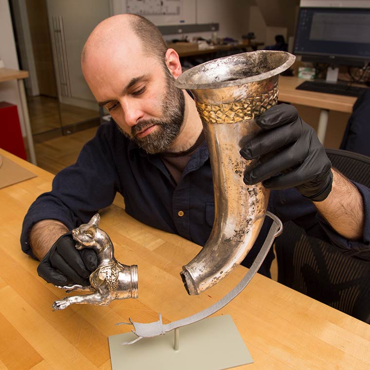 Conservation preparator Warren Bennett mounting a Parthian gilded silver rhyton for display