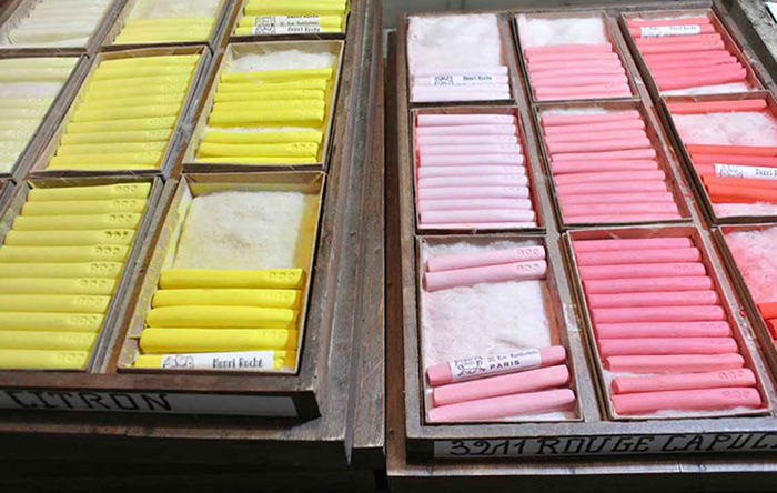 Wooden boxes contain pastel sticks in yellow and pink gradients
