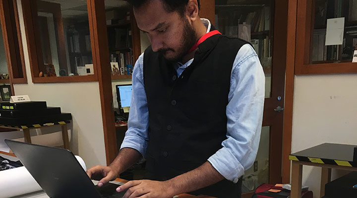 The conservation fellow, NikhilRamesh, seen working on a laptop in the conservation offices and laboratory.