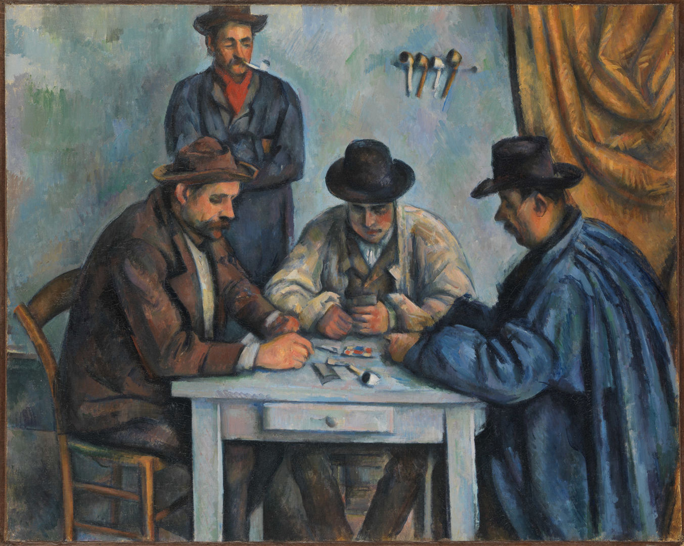Detail of The Card Players by Cezanne. This oil painting depicts three men with hats seated at a small blue table playing cards while a fourth man stands behind them watching them play. A heavy yellow curtain hangs on the left side of a room with blue walls.