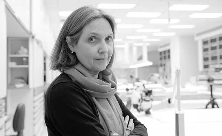 Black-and-white photo of textile conservator Cristina Carr in the lab