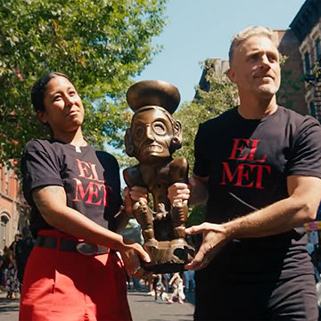 Aya Rodríguez-Izumi and CPP artist in residence Miguel Luciano walk side by side holding a replica of the Zemí Cohoba Stand through the streets of El Barrio.