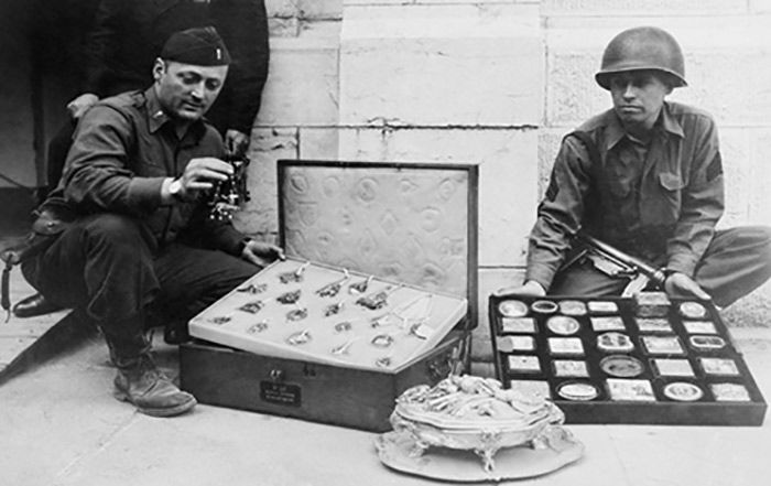 B&W photo of soldiers with suitcases containing small artworks
