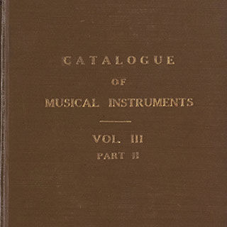 Detail of a brown cloth bound volume with the words "CATALOGUE OF MUSICAL INSTRUMENTS VOL. III PART II" stamped in gold