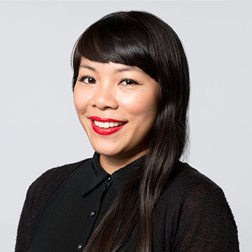 A smiling woman with long dark hair wearing a black blouse