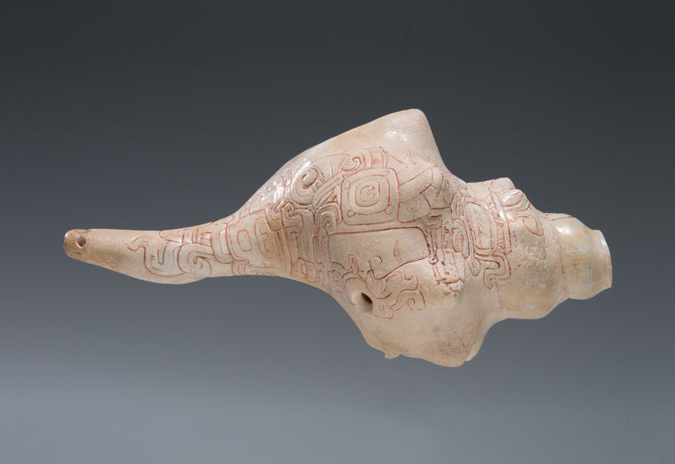 An ancient Maya conch trumpet featuring relief work outlined in crimson cinnabar