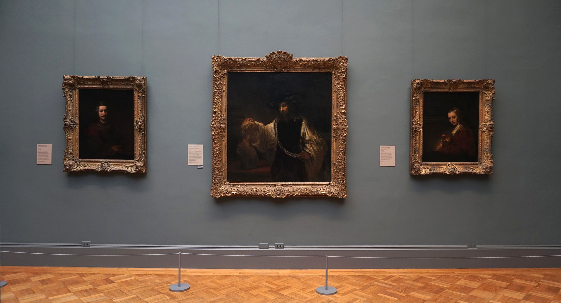 View of a Met gallery wall showing three masterpiece paintings by Rembrandt