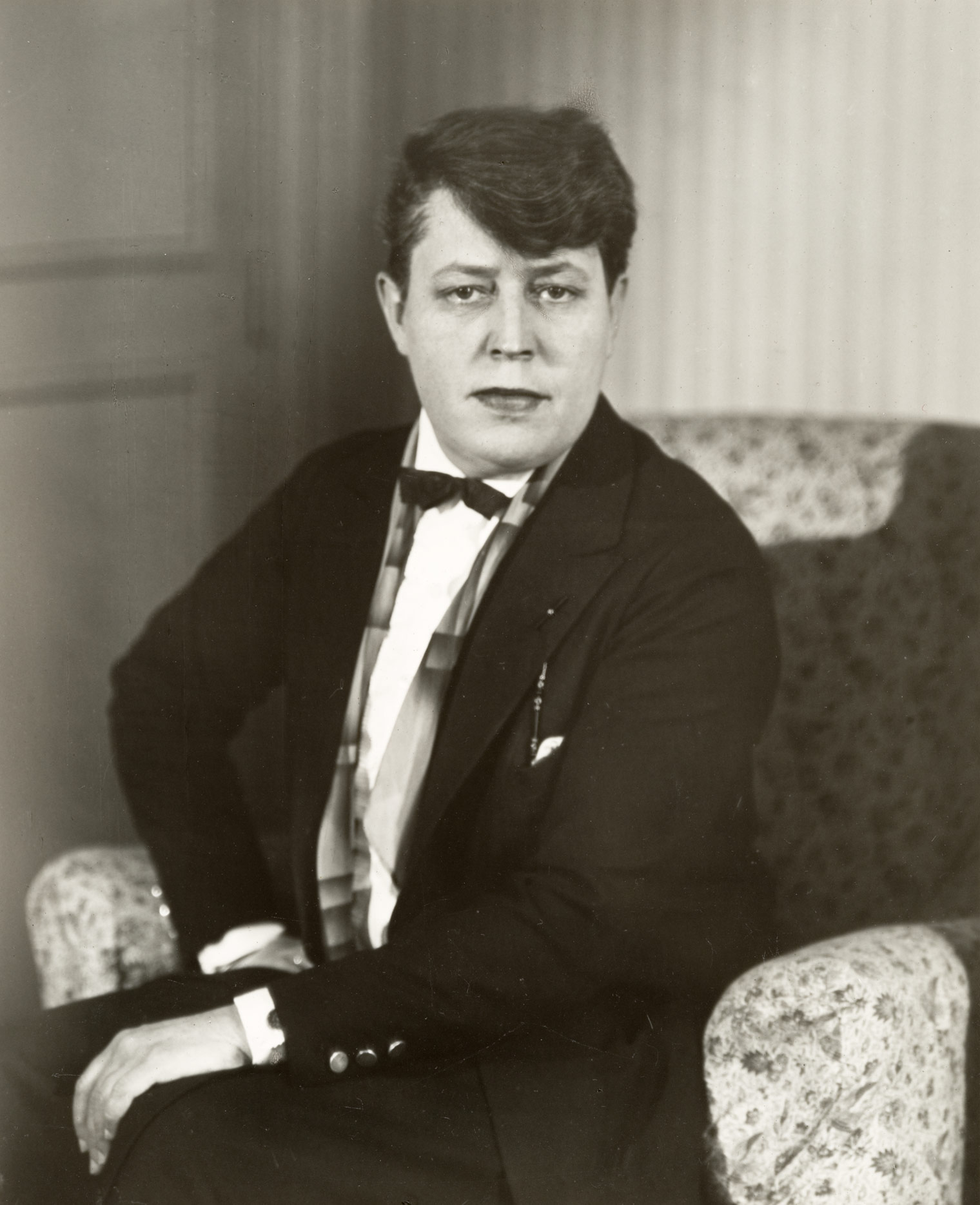 A Berenice Abbott portrait of Jane Heap, showing the sitter wearing a fitted suit and staring intently at the camera