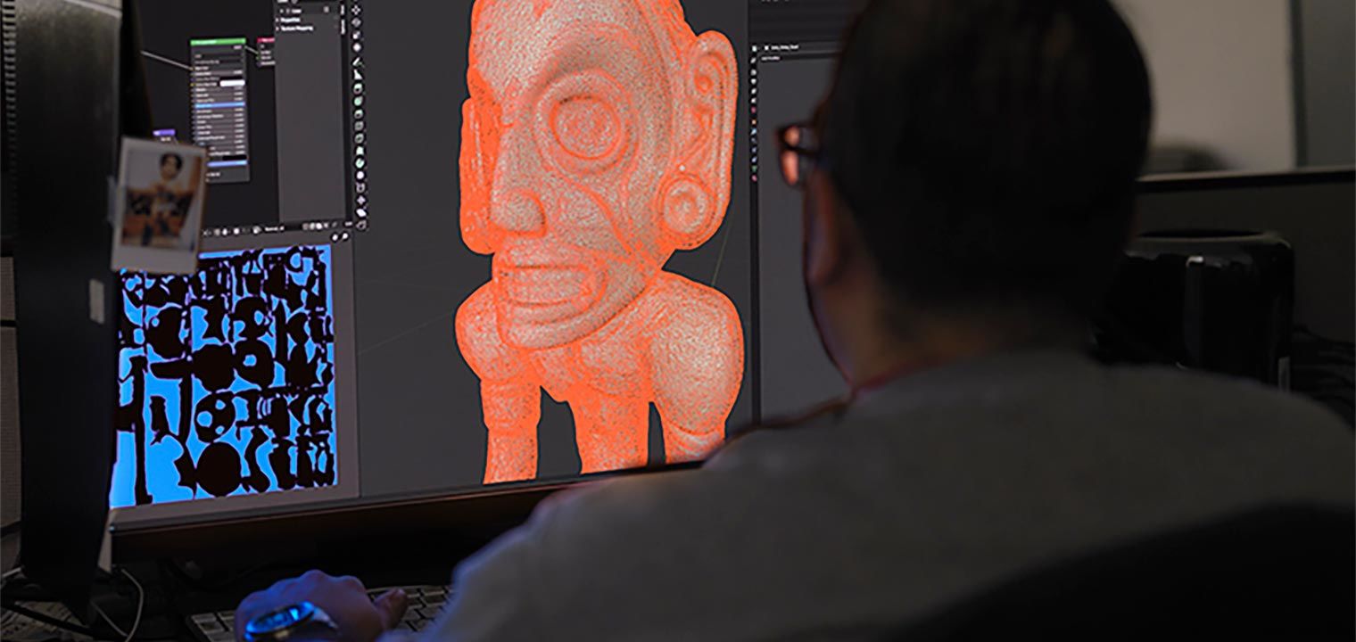 A photo of a man working on a 3D model on a computer