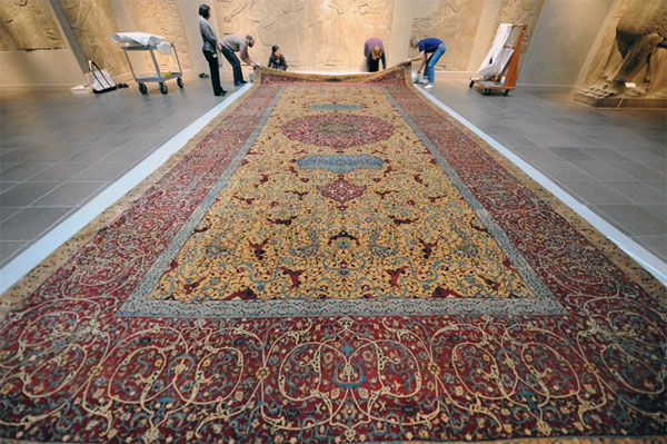 Museum staff work with the Anhalt medallion carpet in gallery 401