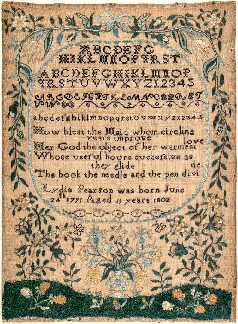 Image of a sampler by Lydia Pearson. The design features the alphabet and poetry embroidered in black thread onto tan linen cloth, surrounded by a border of blue, green, and cream-colored flowers, plants, and shapes.